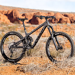 Thumbnail photo of a dark gray Pivot mountain bike in a Southern Utah desert landscape.