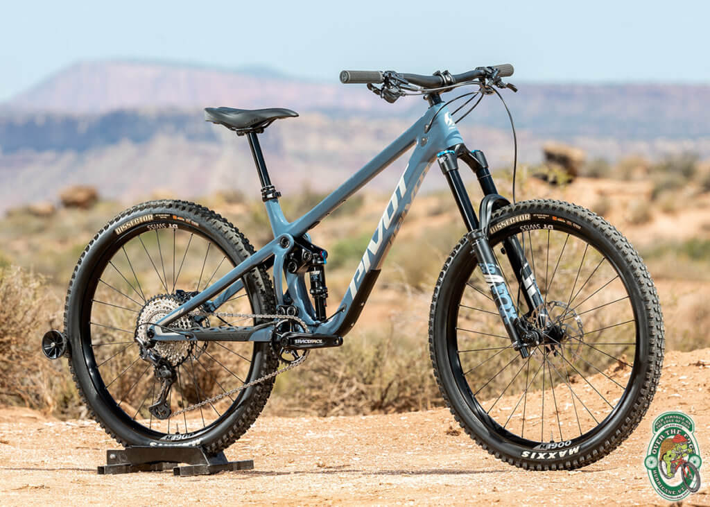 A photo of light blue, Pivot full-suspension mountain bike with a Southwestern background.