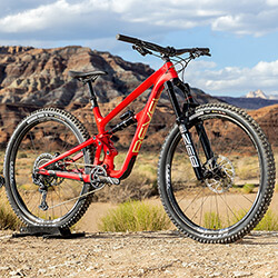 Thumbnail photo of a bright red full-suspension mountain bike against a Southern Utah desert background.